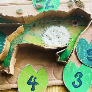 spring play idea - sensory puzzle made of cardboard in the shape of a green frog